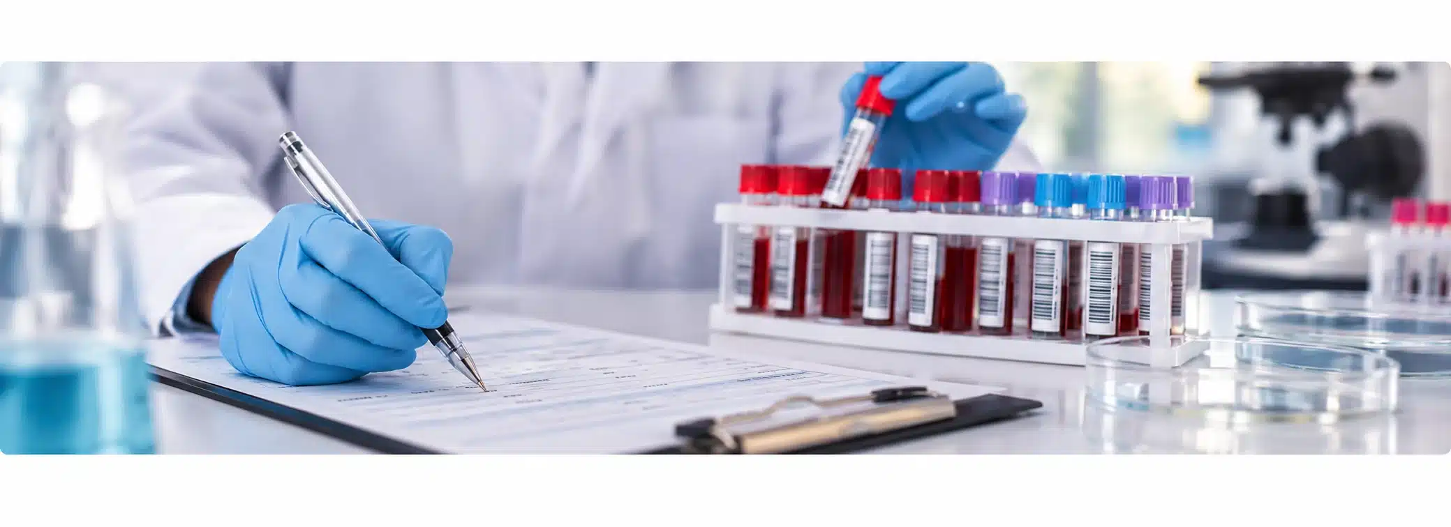 Laboratory technician documenting and handling blood samples during pathology testing workflow at Exodus Immunology